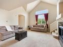 Open living room featuring large windows with red curtains and plush sofas at 1801 S Dunkirk St # 205, Aurora, CO 80017