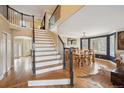 Open foyer featuring hardwood floors, staircase, dining room with stylish light fixture and many windows at 10203 Jill Ave, Highlands Ranch, CO 80130