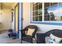 Charming front porch featuring cozy wicker chairs, decorative pillows, and potted plants near the entrance at 1264 Banner Cir, Erie, CO 80516