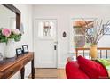 Bright entryway featuring a white front door, wooden table with flowers, and hardwood floors at 1439 S Emerson St, Denver, CO 80210