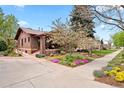 Charming brick home with a manicured front yard, blooming trees, and a welcoming entrance at 1439 S Emerson St, Denver, CO 80210