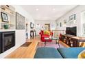 Bright living room with hardwood floors, a fireplace, comfortable seating, and a TV at 1439 S Emerson St, Denver, CO 80210