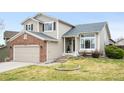Two-story home with neutral siding, brick details, and a well-manicured lawn, offering a classic and inviting aesthetic at 11032 Cannonade Ln, Parker, CO 80138