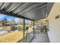Inviting covered porch with metal railing offering a view of the neighborhood at 2800 Albion St, Denver, CO 80207