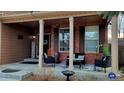 Charming front porch featuring brick columns, comfortable seating, and stylish decor at 5405 S Sicily St, Aurora, CO 80015