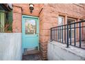 Closeup of a turquoise front door with stone facade and black iron railing at 1610 N Humboldt St # 1/2, Denver, CO 80218