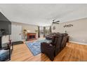 Cozy living room with hardwood floors, fireplace, ceiling fan and comfortable leather sofas at 16650 E Nassau Dr, Aurora, CO 80013