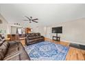 Spacious living room with hardwood floors, ceiling fan, and comfortable leather seating at 16650 E Nassau Dr, Aurora, CO 80013