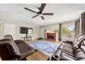 Bright living room featuring hardwood floors, a red brick fireplace, and comfortable seating at 16650 E Nassau Dr, Aurora, CO 80013
