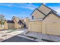 Townhome exterior view featuring attached garages, sidewalk, and wintery ground at 10329 W Fair Ave # C, Littleton, CO 80127