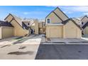 Townhome exterior showcasing attached garages, neutral paint, and minimal snow at 10329 W Fair Ave # C, Littleton, CO 80127