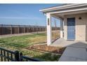 Inviting front porch with blue door, brick facade, and well-manicured lawn and garden area at 27492 E 1St Ave, Aurora, CO 80018