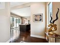 Elegant entryway with hardwood floors, stylish decor, and views of the kitchen and outdoor patio at 15569 W La Salle Ave, Lakewood, CO 80228