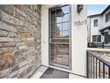 Inviting front door with stone detail, modern address numbers, and a secure screen door at 15569 W La Salle Ave, Lakewood, CO 80228