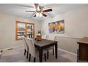 Dining room with dark wood table and chairs, ceiling fan, and window at 10350 W Burgundy Ave, Littleton, CO 80127