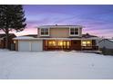 Two-story house with attached two-car garage, covered porch, and snow-covered yard at 10350 W Burgundy Ave, Littleton, CO 80127