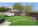 A backyard with an artificial lawn and a wooden fence with an outdoor seating area at 483 S Kingston Cir, Aurora, CO 80012