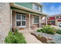 A well-decorated front porch with brick columns, a green ceiling, and a decorative security door at 483 S Kingston Cir, Aurora, CO 80012