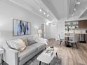 Bright living room featuring a comfortable gray sofa, modern decor, and seamless flow into the dining and kitchen areas at 1495 Vrain St # 214, Denver, CO 80204