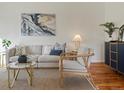 Bright living room with modern furnishings, hardwood floors, and an artful painting at 2850 Lowell Blvd, Denver, CO 80211