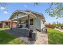 Stylish exterior showcasing a covered front porch with gray tones and a well-manicured lawn at 4504 N Clay St, Denver, CO 80211