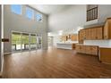 Bright and airy living room featuring hardwood floors and a soaring vaulted ceiling and lots of natural light at 1694 Fox Trotter Pt, Castle Rock, CO 80104