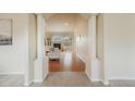 Welcoming foyer that features light, neutral colors and leads into the living room with a fireplace and large windows at 1520 Symphony Hts, Monument, CO 80132