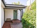 Inviting front porch with brick flooring, bench seating, and a charming green front door at 2719 S Truckee St, Aurora, CO 80013