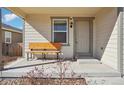 Inviting front porch with a bench, neutral siding, and well-maintained landscaping at 2015 Wildwood St, Lochbuie, CO 80603