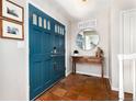 Inviting entryway with teal double doors, terra cotta tile flooring, and decorative accents at 7142 S Hudson Ln, Centennial, CO 80122