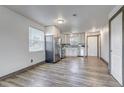 Open kitchen with stainless steel appliances and white cabinetry, seamlessly connecting to the living area at 1135 S Gilbert St # 103, Castle Rock, CO 80104