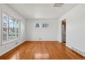 Sunlit open room featuring sleek hardwood floors and stainless steel appliances nearby at 7180 Zuni St, Denver, CO 80221