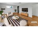 Bright living room with hardwood floors, modern furniture, and a large window at 7180 Zuni St, Denver, CO 80221