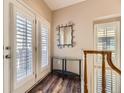 Bright entryway featuring hardwood floors, a decorative mirror, and a staircase at 10578 Parkington Ln # 35D, Highlands Ranch, CO 80126