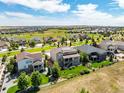 Aerial view showcasing a neighborhood with houses and a golf course in the background at 7609 S Country Club Pkwy, Aurora, CO 80016