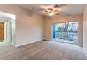 Bright bedroom featuring a ceiling fan and a sliding glass door to a balcony at 8416 Pebble Creek Way # 203, Highlands Ranch, CO 80126