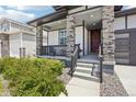 Inviting front porch with stone columns and seating, perfect for relaxing outdoors at 5680 Saddle Skirt St, Parker, CO 80134