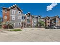 Exterior view of a well-maintained three-story condo building with ample parking at 14251 E 1St Dr # 305, Aurora, CO 80011