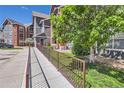 View of a ramp leading to a condo building with manicured landscaping and a green lawn at 14251 E 1St Dr # 305, Aurora, CO 80011