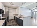 Stylish eat-in kitchen boasts stainless appliances, wood-look flooring, and a breakfast bar opening to the living area at 14251 E 1St Dr # 305, Aurora, CO 80011