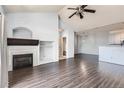 Vaulted living room features hardwood floors, a fireplace, ceiling fan, and access to a patio at 14251 E 1St Dr # 305, Aurora, CO 80011