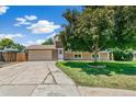 Charming home with a well-manicured lawn and a spacious driveway leading to a two-car garage on a sunny day at 8539 W Duquesne Dr, Lakewood, CO 80227