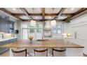 Bright kitchen featuring wood beams, a large center island, and modern light fixtures at 106 S University Blvd # 5, Denver, CO 80209