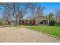 Quaint brick home with a well-maintained lawn and a long, private gravel driveway at 10490 W 78Th Ave, Arvada, CO 80005
