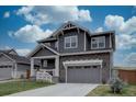 Charming two-story home with a gray exterior, covered porch, and attached two-car garage at 1031 Turnberry Cir, Louisville, CO 80027
