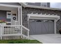 Close-up of the home's gray two-car garage with a decorative pergola and stone detailing at 1031 Turnberry Cir, Louisville, CO 80027