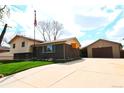 Spacious home with a large driveway and detached garage, offering ample parking and storage space at 11823 Williams Way, Northglenn, CO 80233