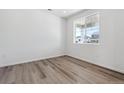 Bright, empty bedroom with light wood flooring and a large window at 18971 E 96Th Pl, Commerce City, CO 80022