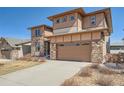 Charming two-story house with a two car garage, stone and wood accents, and a well kept front yard at 7994 S Kewaunee St, Aurora, CO 80016