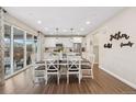 Cozy dining area adjacent to kitchen with wood flooring, pendant lighting, sliding glass doors to the backyard at 16400 Alberta Dr, Parker, CO 80134